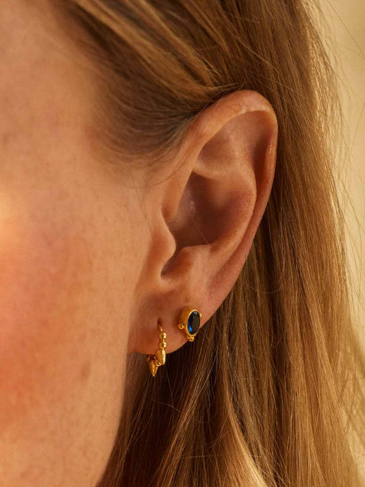 pointed minimal gold huggie close up on earlobe