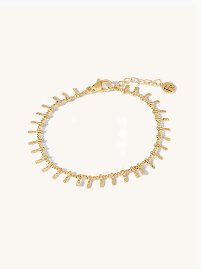 Gold bracelet with small bar texture on a white background