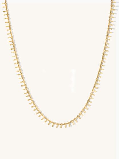 Gold textured bar necklace on a white background