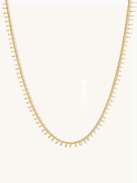 Gold textured bar necklace on a white background