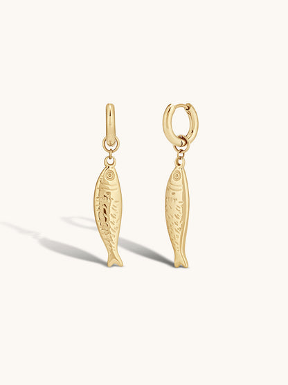 Gold fish-shaped earrings on a white background