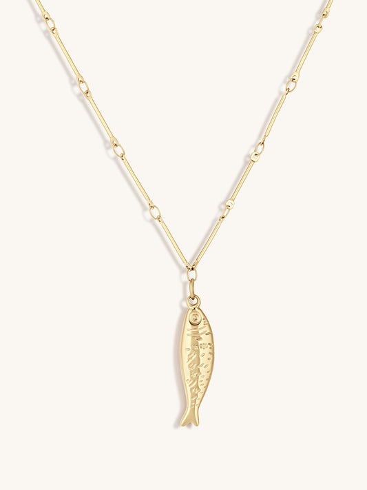 Gold fish pendant necklace on a white background