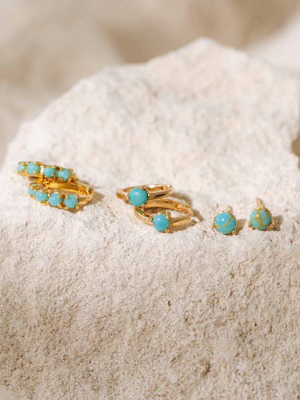 turquoise and gold huggie and stud set on rocks