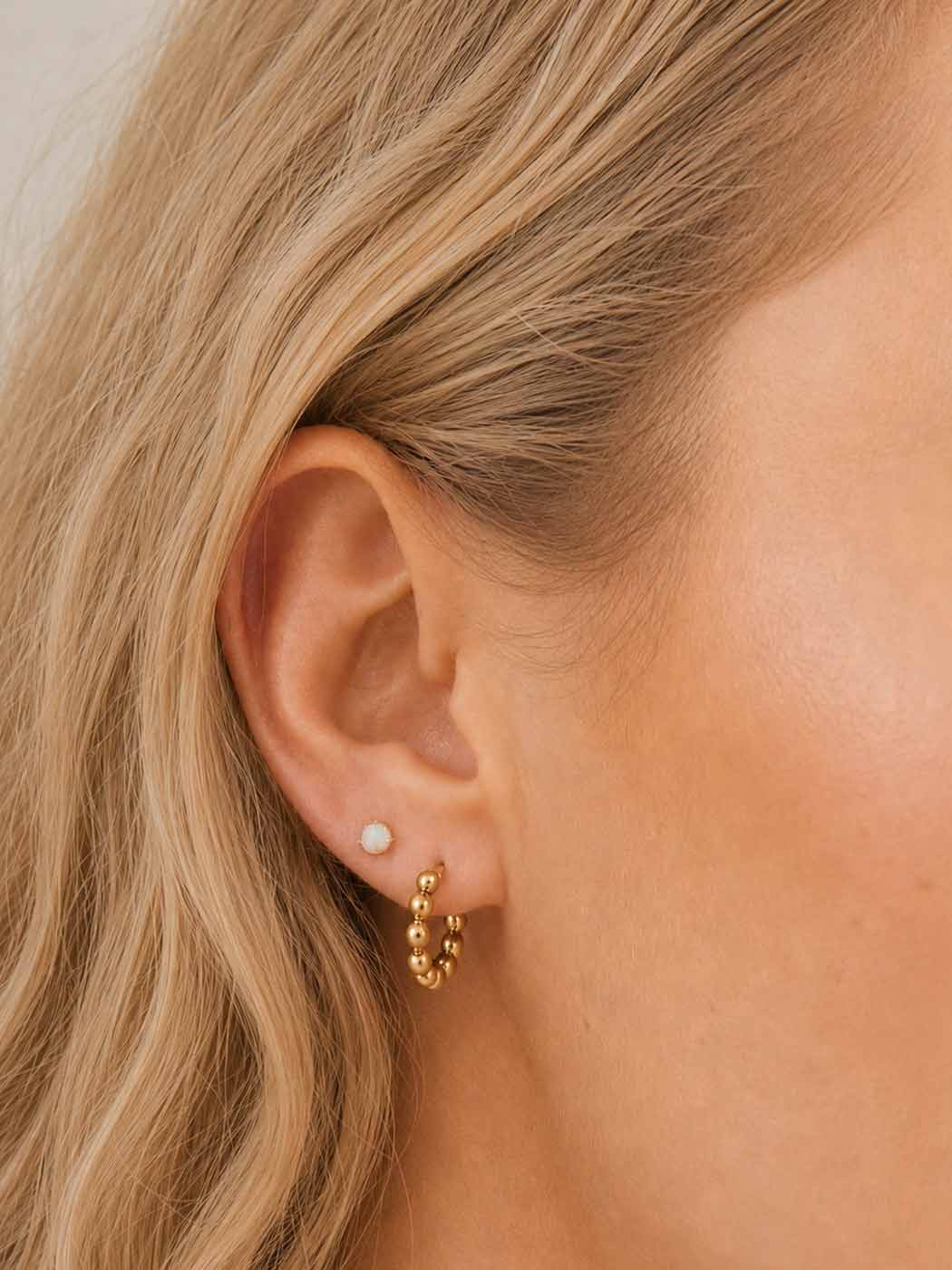 delicate gold rounded opal stud on ear