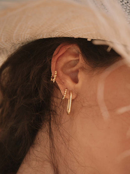 gold huggie stack featuring pointed huggie and beaded huggie close up