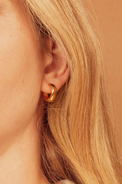 MINI-CHUBBY-GOLD-INFINITY-HOOP-EARRINGS-FLAT-LAY-ON-BODY